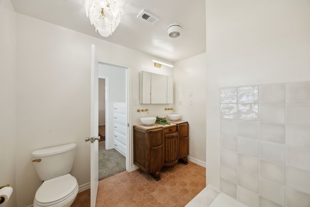 bathroom featuring vanity, toilet, baseboards, and visible vents