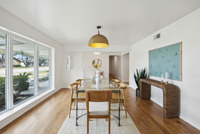 dining area featuring baseboards, visible vents, and light wood-type flooring