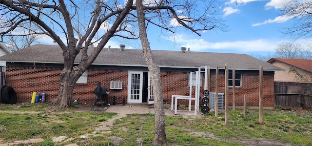 back of house featuring a patio area, fence, brick siding, and roof with shingles