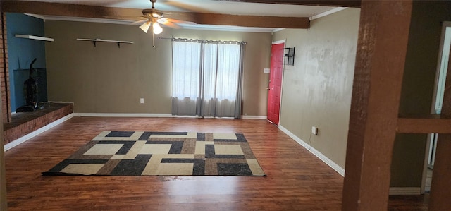 unfurnished living room with beam ceiling, ceiling fan, baseboards, and wood finished floors