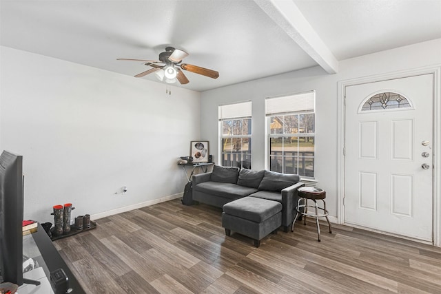 living area with beamed ceiling, baseboards, wood finished floors, and a ceiling fan