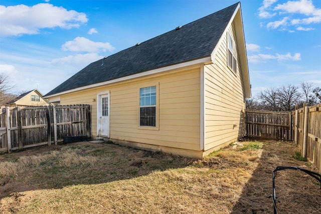 view of side of property with a fenced backyard and a shingled roof