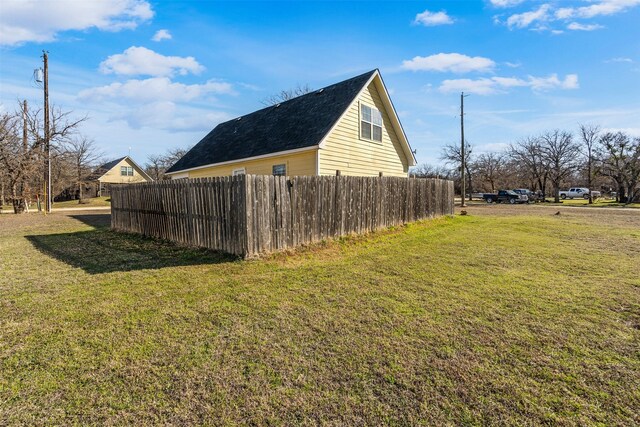 view of side of property with a yard and fence