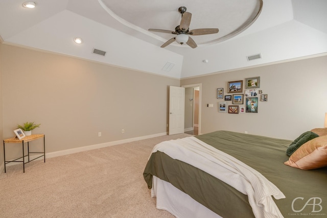 carpeted bedroom featuring a tray ceiling, visible vents, baseboards, and vaulted ceiling