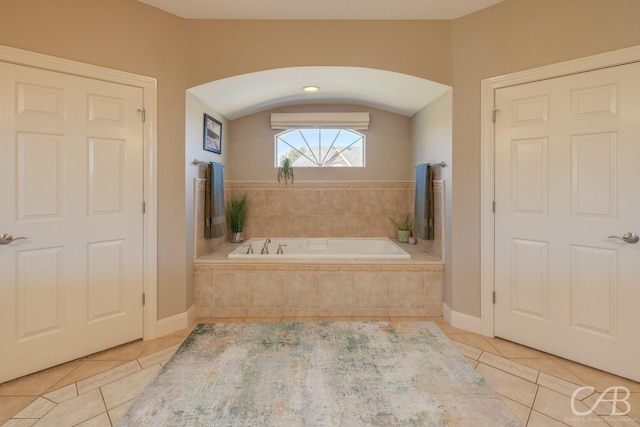 bathroom featuring tile patterned floors and a garden tub