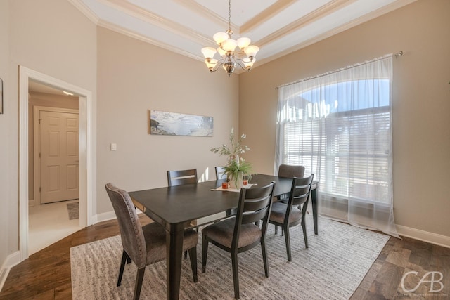 dining space featuring crown molding, baseboards, a chandelier, wood finished floors, and a raised ceiling