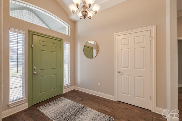 entryway with plenty of natural light, baseboards, dark wood-style flooring, and a chandelier