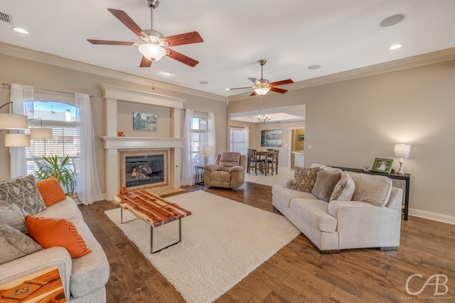 living room with ornamental molding, a tiled fireplace, wood finished floors, recessed lighting, and baseboards