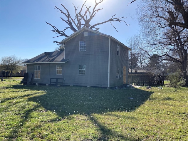 rear view of property featuring a lawn