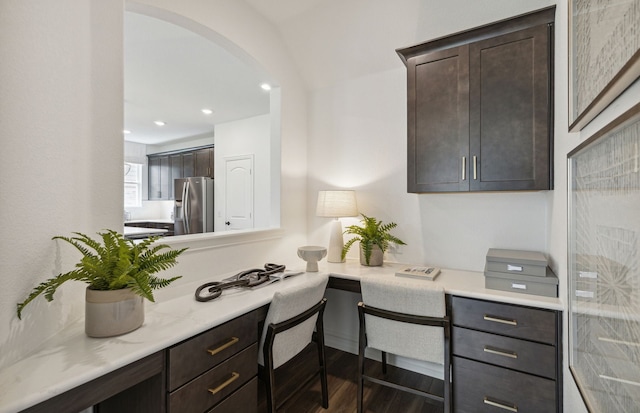 home office with arched walkways, recessed lighting, built in study area, and wood finished floors