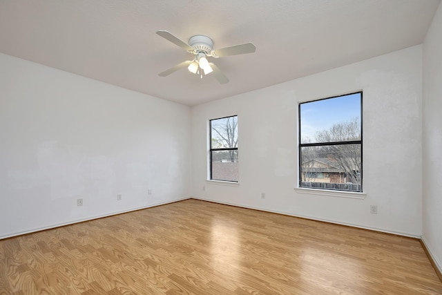 empty room with baseboards, light wood-type flooring, and ceiling fan