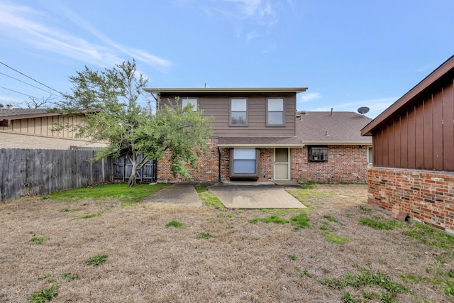 back of property featuring brick siding, a patio, and fence