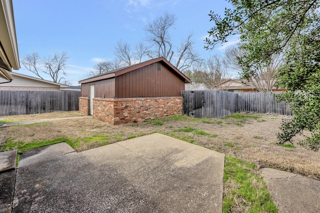 exterior space featuring brick siding, a patio area, and a fenced backyard