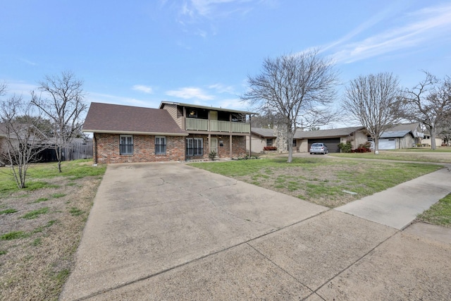 view of front of house with a front yard, a balcony, a shingled roof, concrete driveway, and brick siding