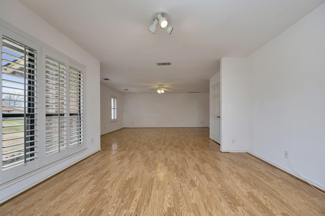 unfurnished room with visible vents, baseboards, ceiling fan, and light wood finished floors