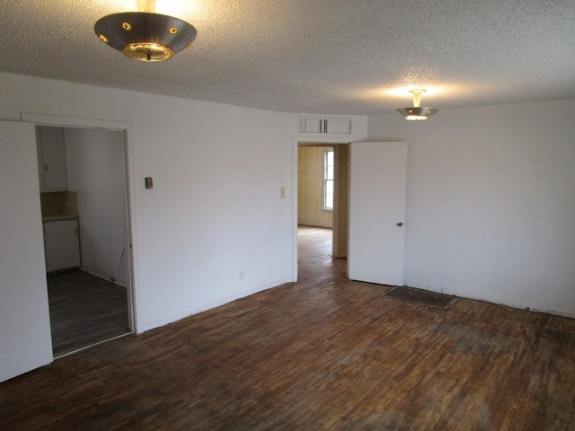 spare room with visible vents, a textured ceiling, and wood finished floors