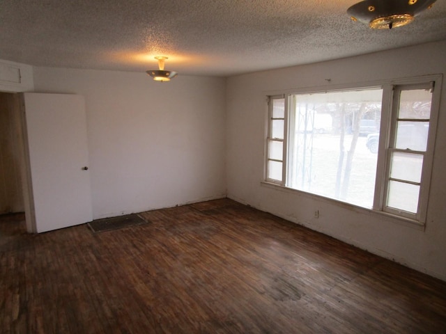 spare room with dark wood finished floors and a textured ceiling