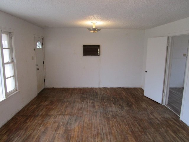 unfurnished room featuring wood finished floors, a wealth of natural light, and a textured ceiling