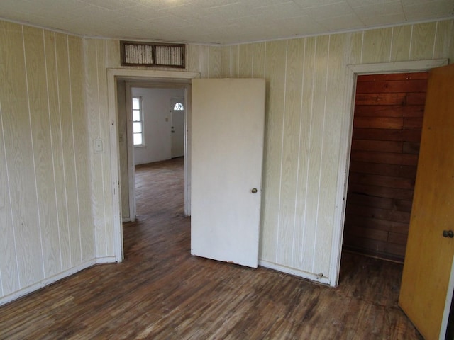 spare room featuring wooden walls and wood finished floors