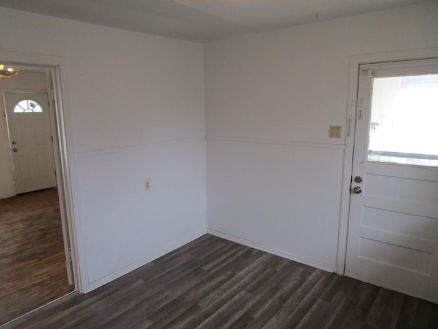 spare room featuring dark wood finished floors and plenty of natural light