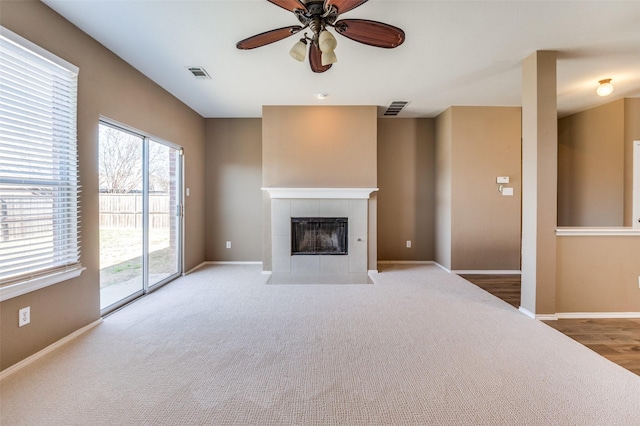 unfurnished living room with a fireplace, visible vents, and baseboards