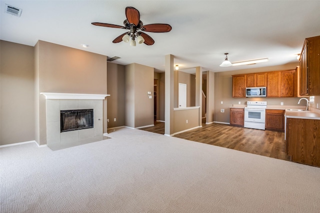 kitchen with stainless steel microwave, visible vents, white electric range, and a sink