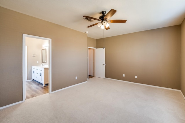 unfurnished bedroom with visible vents, baseboards, a sink, light carpet, and connected bathroom