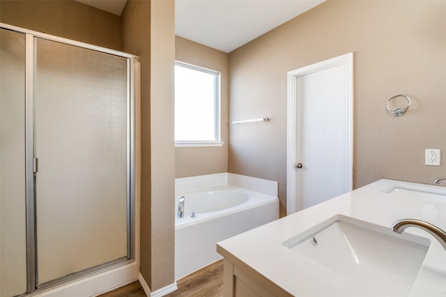 bathroom with a bath, a stall shower, and a sink