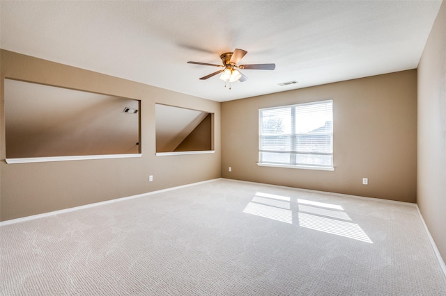 carpeted empty room with visible vents, baseboards, and ceiling fan