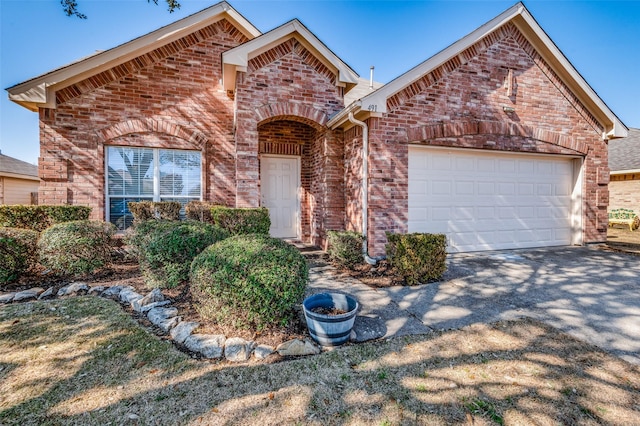 view of front of property featuring a garage, brick siding, and driveway