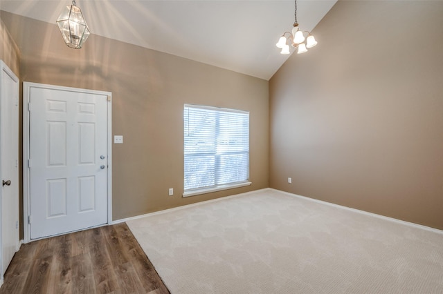 carpeted foyer entrance with baseboards, a notable chandelier, and high vaulted ceiling