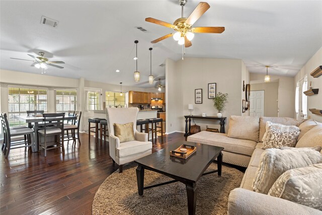 living room with vaulted ceiling, visible vents, dark wood-style flooring, and ceiling fan