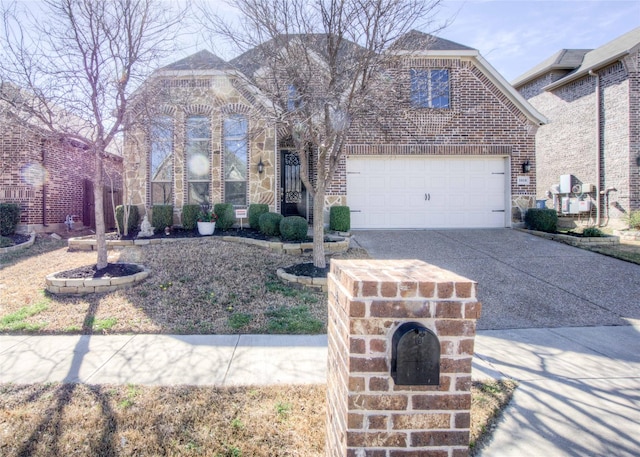 view of front of home featuring stone siding, an attached garage, brick siding, and driveway