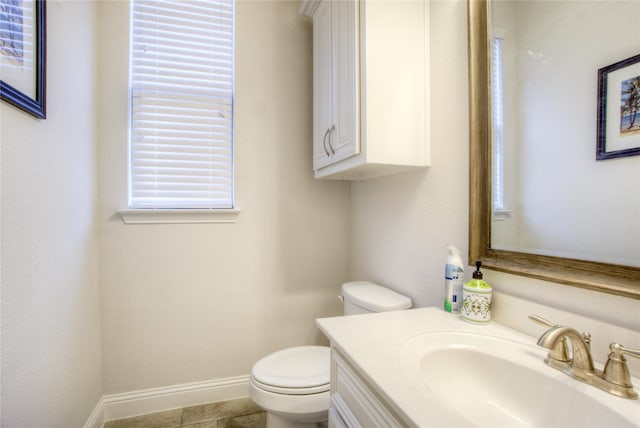 half bath featuring toilet, vanity, and baseboards