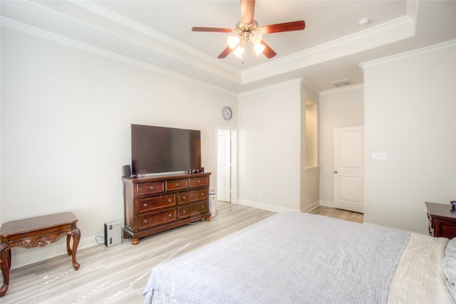 bedroom featuring visible vents, crown molding, light wood-type flooring, and a raised ceiling