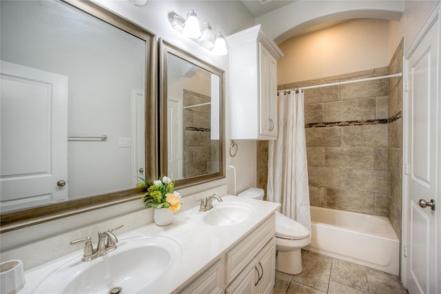 bathroom featuring double vanity, shower / bathtub combination with curtain, toilet, and a sink