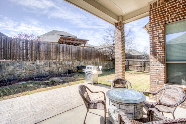 view of patio / terrace with a fire pit, a fenced backyard, and a grill