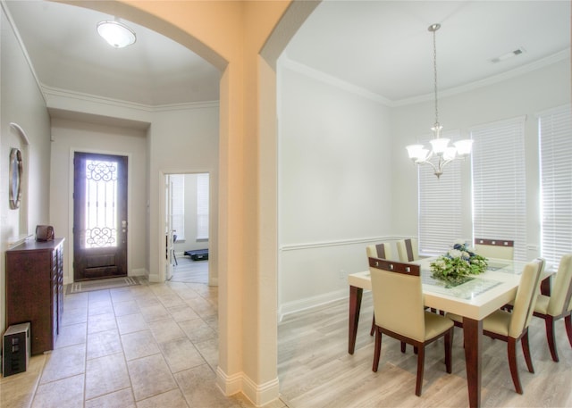 dining room with visible vents, arched walkways, crown molding, baseboards, and a chandelier