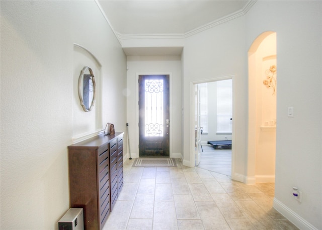 entryway with light tile patterned floors, baseboards, arched walkways, and crown molding