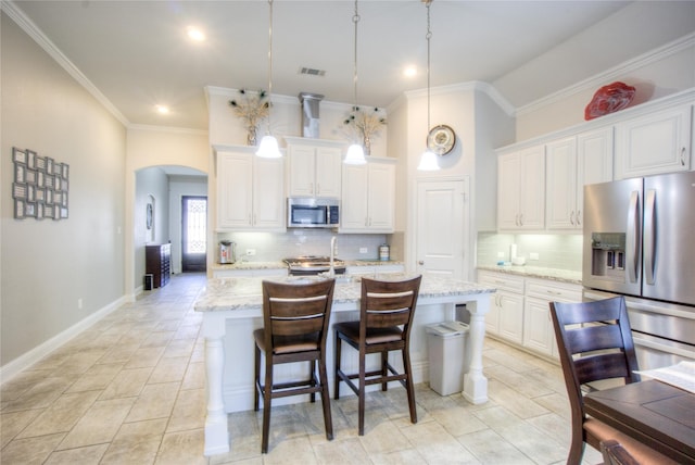 kitchen featuring visible vents, decorative backsplash, appliances with stainless steel finishes, arched walkways, and white cabinets