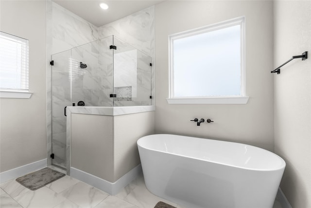 bathroom with a freestanding tub, baseboards, marble finish floor, and a marble finish shower