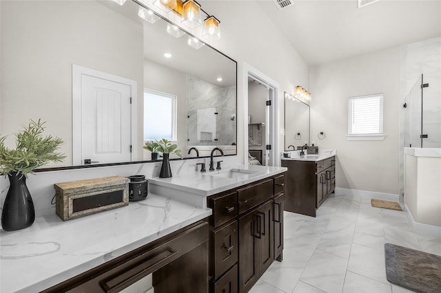 bathroom featuring a sink, baseboards, two vanities, and a shower stall