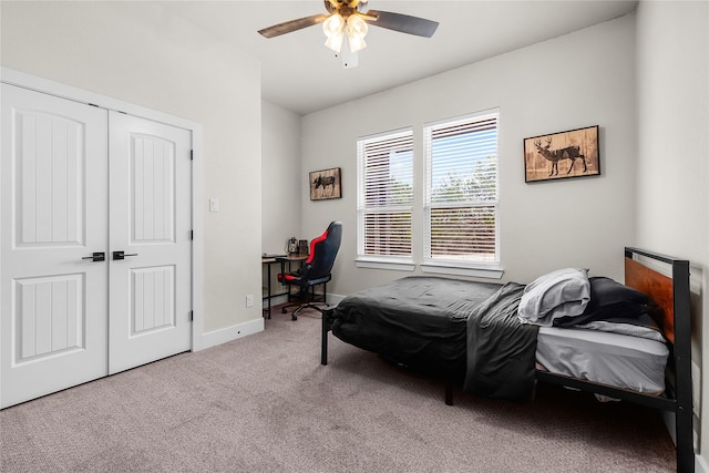 carpeted bedroom featuring a closet, ceiling fan, and baseboards