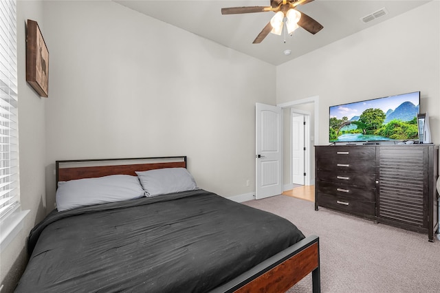 bedroom featuring visible vents, light colored carpet, and a ceiling fan