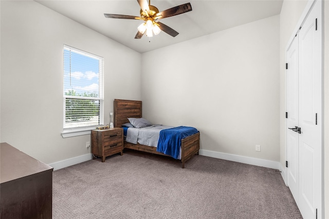 bedroom with baseboards, light carpet, a closet, and ceiling fan