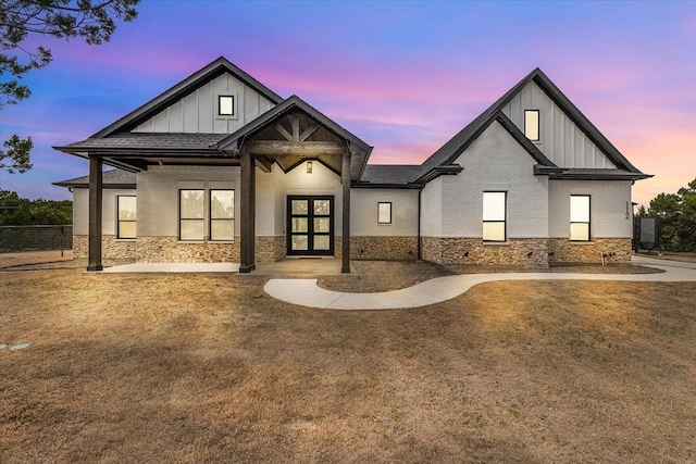 modern farmhouse with brick siding, stone siding, board and batten siding, and fence