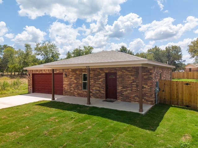 back of property featuring brick siding, driveway, a garage, and fence