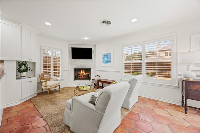 living area with recessed lighting, visible vents, a fireplace, and crown molding