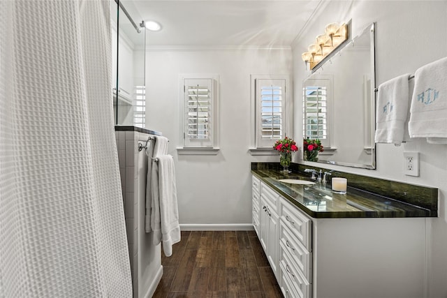 bathroom featuring ornamental molding, wood finished floors, a shower with shower curtain, baseboards, and vanity