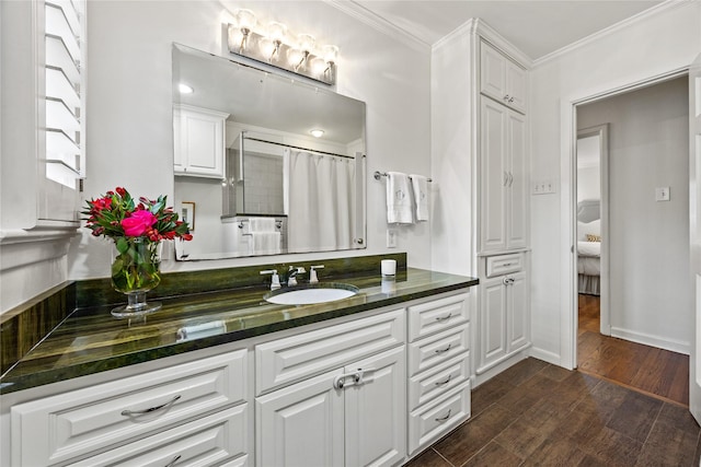 bathroom with vanity, a shower with shower curtain, wood finished floors, baseboards, and ornamental molding